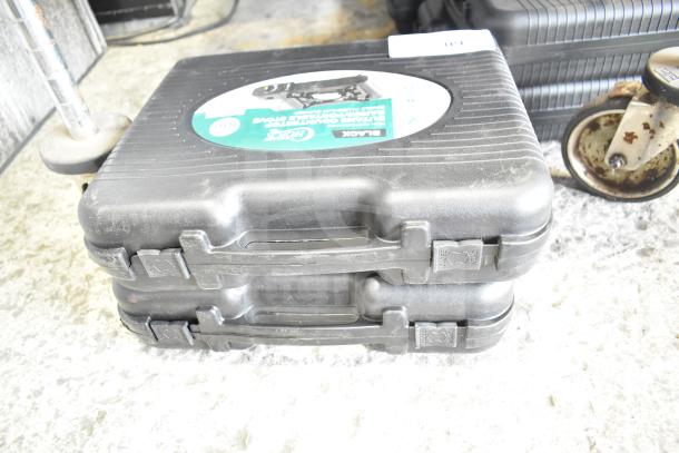 Two Choice 472E10SL 1-Burner Butane Ranges, 8000 BTU, new with scratches, in black carrying cases with labels showing specs.