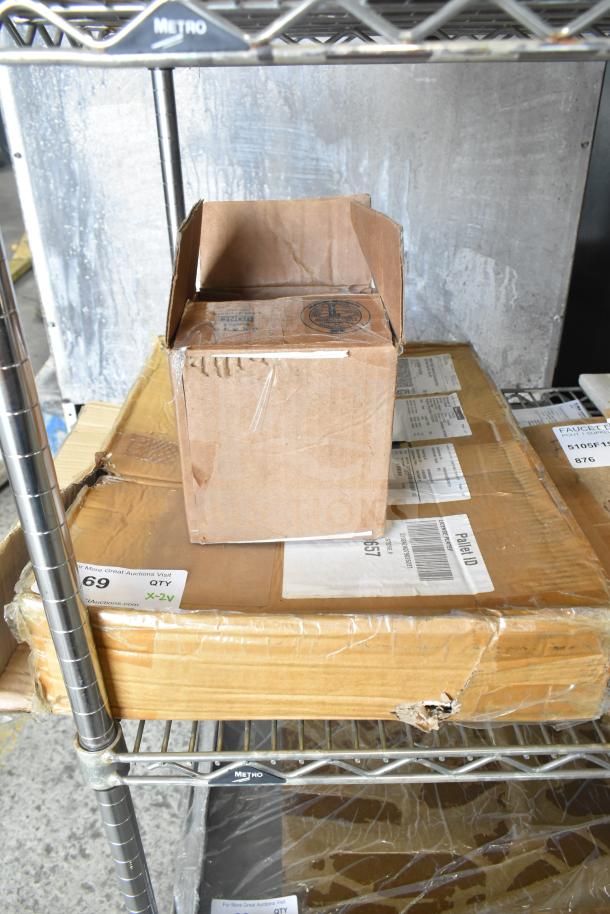 Brown cardboard box on a metal shelf containing new scratch and dent items, including CHNT CJX2-18 with GB/T 14048.5.