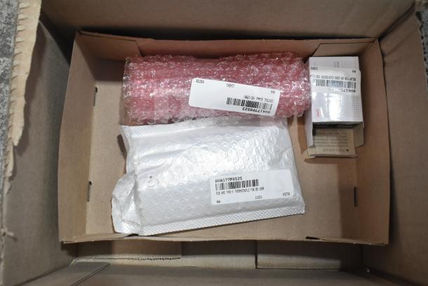 Four new items in bubble wrap and boxes, including thermocouple, control board, and pilot assembly, in original packaging.