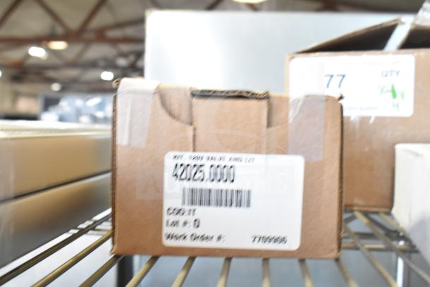 Cardboard box labeled "42025.0000" with barcode, on a metal shelf in a warehouse setting.