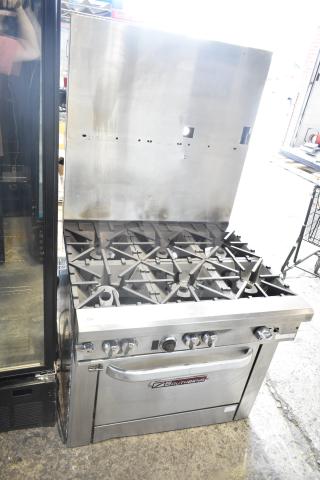 Southbend commercial gas-powered 6 burner range with oven and backsplash. Features stainless steel finish and control knobs.