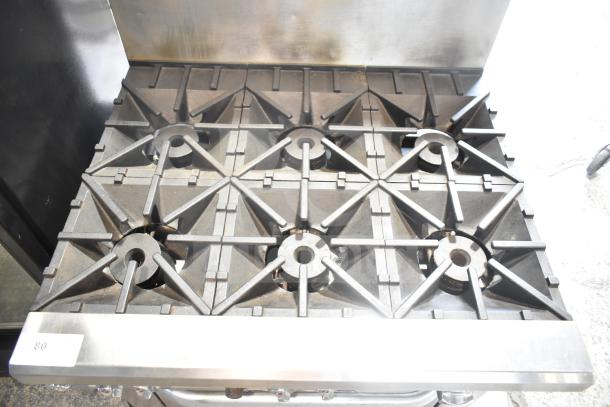 Southbend commercial gas 6-burner range with oven, stainless steel backsplash, visible wear, model label reads "83."