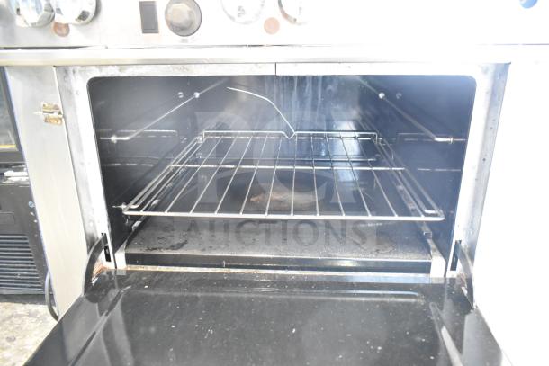 Southbend commercial gas-powered 6-burner range with oven and backsplash, showing interior. Features sturdy racks. Good condition.