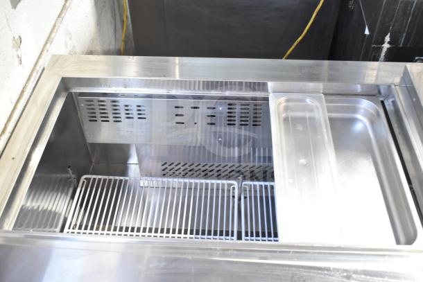 Atosa commercial prep table, stainless steel, 115 volts, 1 phase. Open top view showing metal racks and compartments.