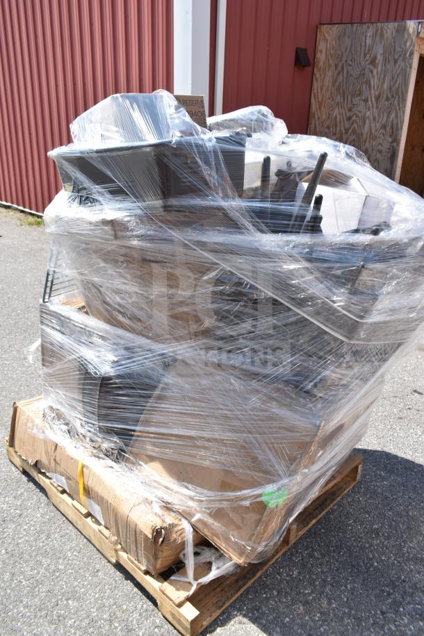 Sealed pallet of 17 new scratch-and-dent items, including a work table and glasses, wrapped in clear plastic.