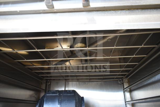 Stainless steel interior of LVO FL14E commercial pot and pan washer, 460V, 3 phase, front load, showing spray arms and racks.