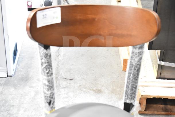 10 Lancaster Boomerang chairs, new, wooden backrest, gray cushion, metal frame. Scratch and dent sale. Tags visible.