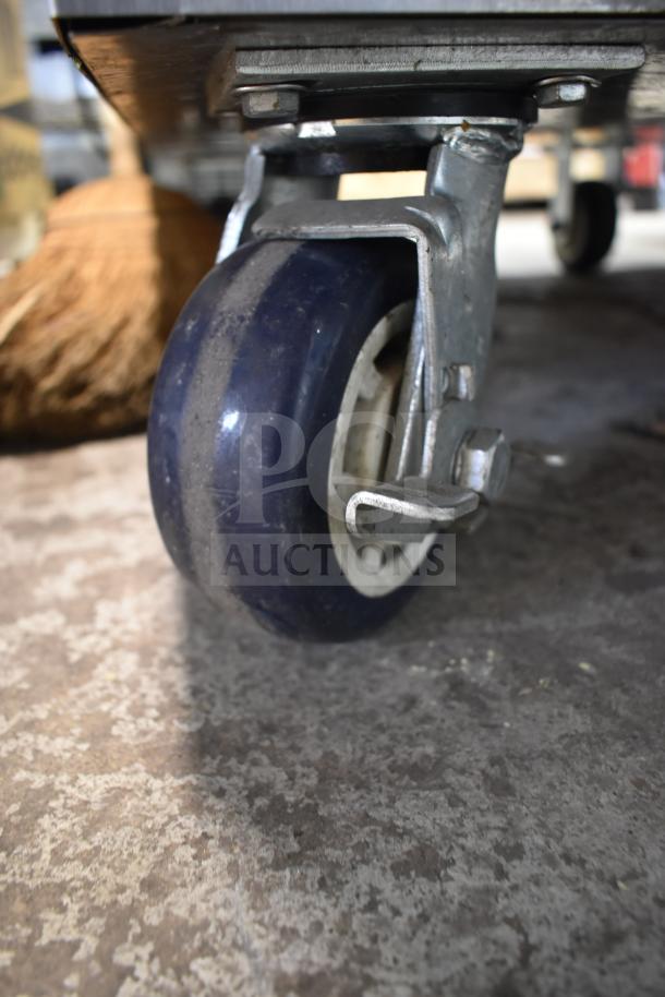 2024 FWE TS-1633-36P Heated Holding Cabinet caster close-up. Features durable metal frame and locking mechanism.