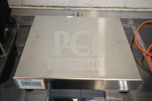 Mettler Toledo BC Commercial Food Portioning Scale, stainless steel surface, used condition, visible ID tag with calibration details.