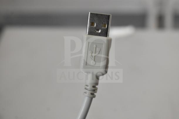 A close-up image of a USB Type-A plug with a white plastic casing and USB symbol embossed on it.