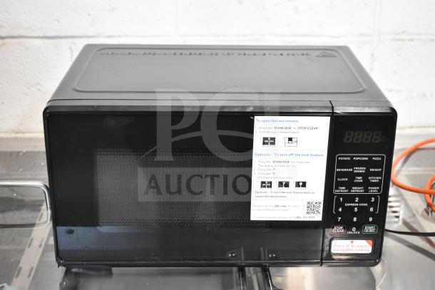 Brand new, scratch and dent Hamilton Beach MS8436127995-01 countertop microwave oven, 120V, 1-phase; instructional label visible.
