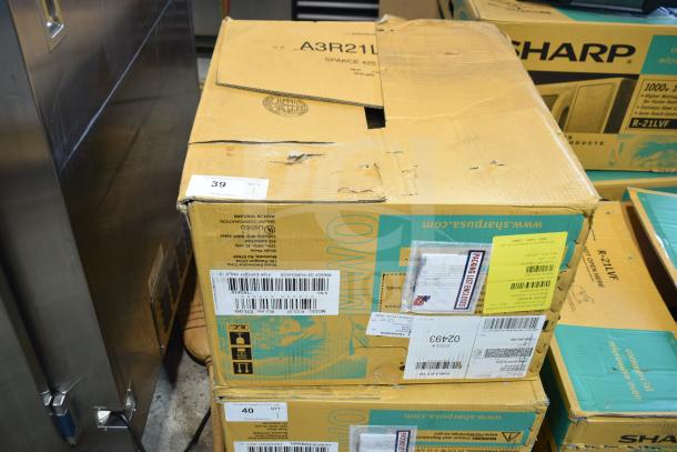 Cardboard box of 2023 Sharp R-21LVF Commercial Countertop Microwave Oven, showing handling instructions and shipping labels.