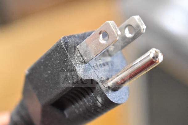 Close-up of a three-pronged electrical plug, part of the Sharp R-21LVF Commercial Microwave, 120 Volts, 1 Phase.