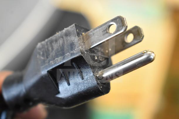 A close-up of the plug for a 2016 Hobart HTi-7LH commercial food portioning scale, showing three metal prongs.