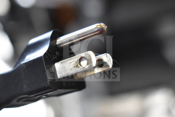 Close-up of a power plug compatible with the 2023 Bunn VPR coffee brewer, highlighting the prongs for 120 volts, 1 phase connection.