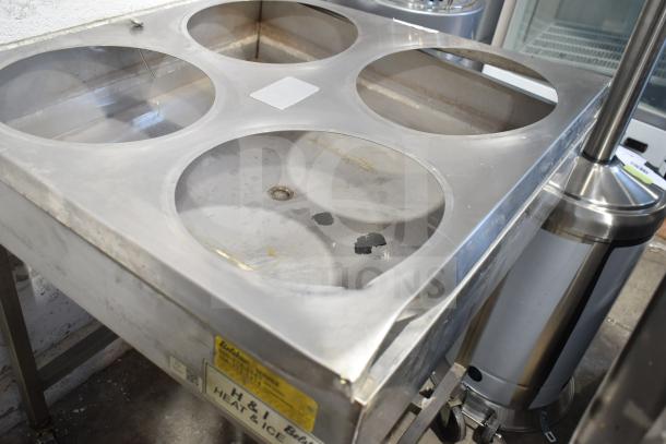 Belshaw H&I Commercial Heat and Ice Icing Station with four circular openings, on casters, metal surface. 208V, 1 Phase.
