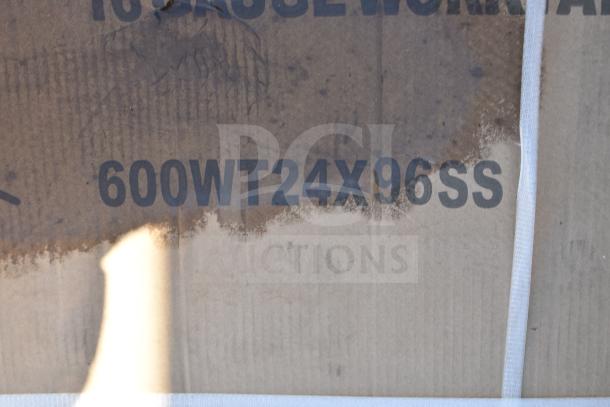 Cardboard box labeled "600WT24X96SS," indicating work table dimensions. Box appears slightly worn.