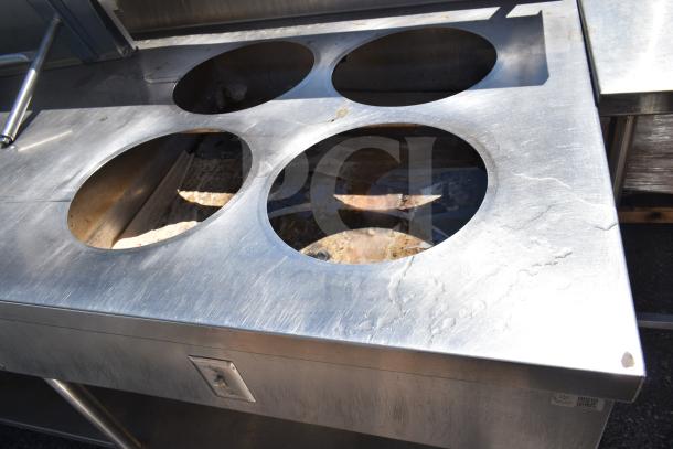 Commercial prep table with 4 round cut outs for sauce pots, 2 drawers, and commercial casters, stainless steel, used condition.