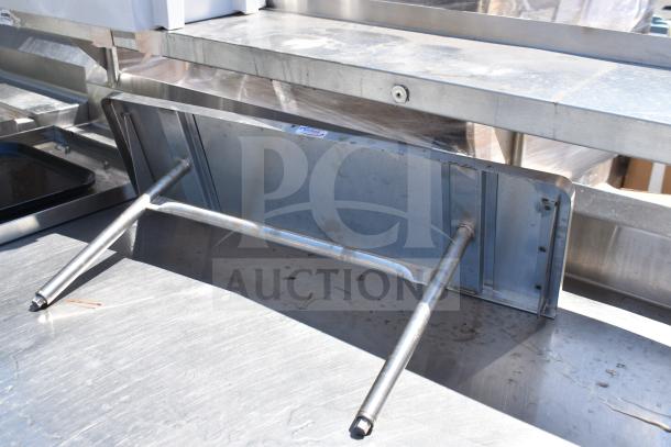 Commercial stainless steel prep table with four round cutouts, two drawers with sauce pot cutouts, on commercial casters.