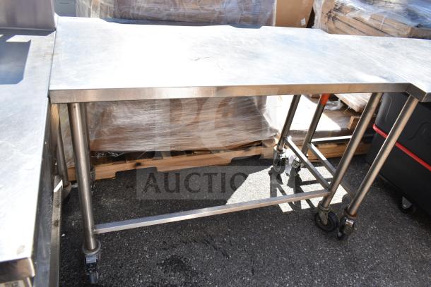 Stainless steel commercial table on heavy-duty casters, rectangular shape, sturdy construction, suitable for industrial use.