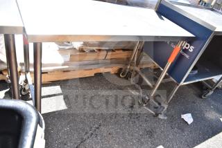 Commercial metal table with robust build on heavy-duty commercial casters. Used condition, suitable for industrial use.