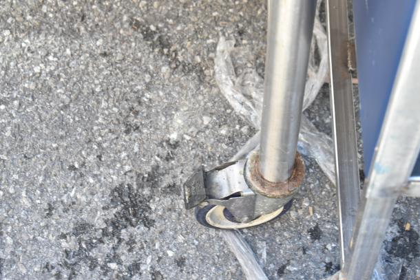 Commercial table leg with caster wheel, showing rust on metal parts, indicating moderate wear and usage.