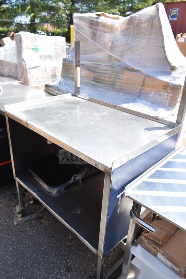 Commercial portable counter with under shelf, metal construction, on commercial casters, used condition.