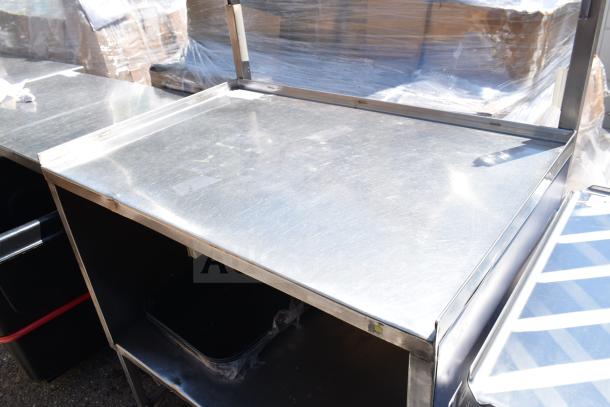 Commercial portable counter with under shelf and commercial casters, stainless steel finish, used condition.