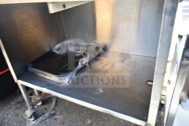 Commercial portable counter with under shelf, made of stainless steel. Equipped with sturdy commercial casters. Minimal wear.