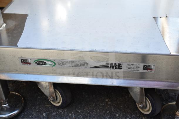 Face to Face Commercial Meat Slicer Equipment Stand with visible M&E Mfg. Co. label, metal construction, on wheels.