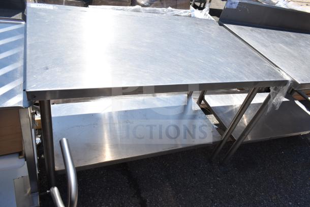 Commercial stainless steel table with under shelf, in good condition, ideal for kitchen or workshop use, sturdy design.