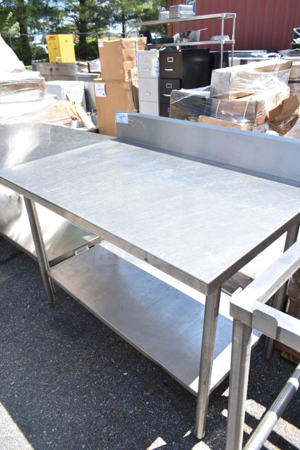 Stainless steel commercial table with back splash and under shelf, in good condition. Ideal for kitchen use.