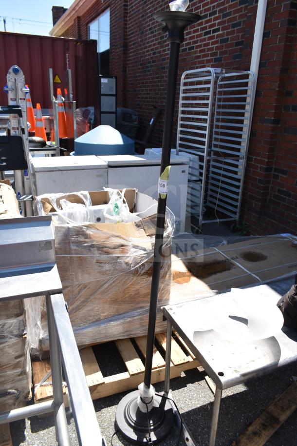 Outdoor floor lamp with black pole, round base, and exposed bulb. Tags read "50" indicating batch or lot number.