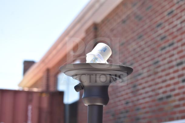 Outdoor lamp with bulb socket, matte black finish, placed against a brick wall background, no visible bulb.