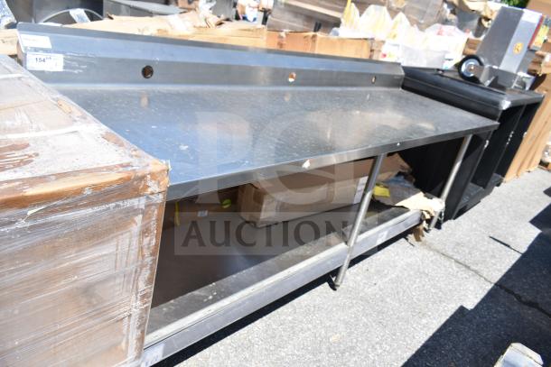 Winholt commercial table with backsplash and under shelf, stainless steel, used condition, auction tag visible.