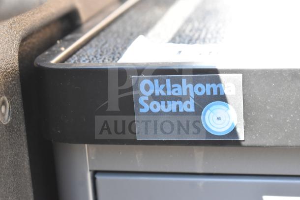 Auction item: New Oklahoma Sound DCC Duet Charging Cart, black/charcoal, slight scratches/dents. Oklahoma Sound label visible.