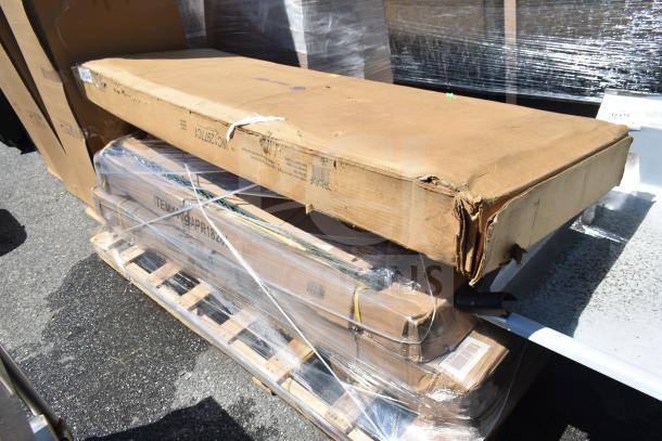 8 boxes of scratch and dent items, shrink-wrapped, including a pan rack and work table, on a pallet outdoors.