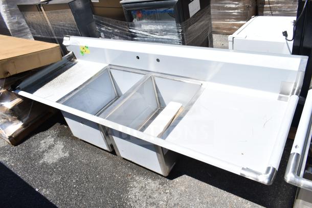 BRAND NEW Regency 600S21824224 commercial 2-bay sink with dual drain boards, minor scratches, stainless steel construction.
