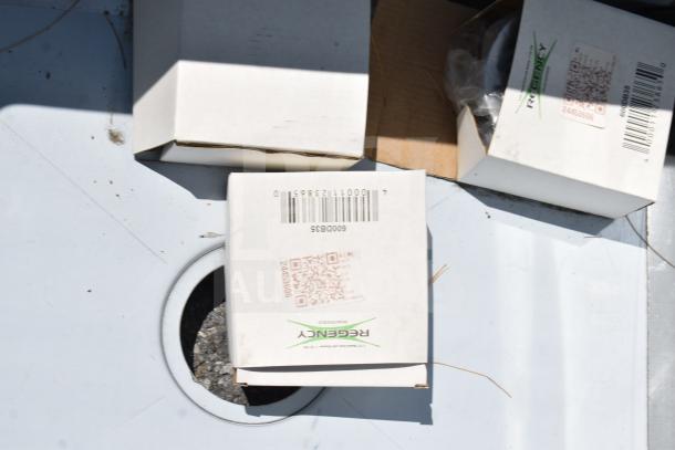 Boxes on a surface, one labeled "Regency." Likely packaging for Regency 600S3182424R commercial sink components.
