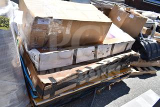 Stacked cardboard boxes labeled as scratch and dent items, including a sink, in brand new condition. Signs of wear on packaging.