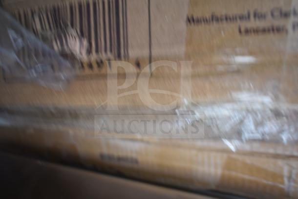 Blurry image of cardboard boxes for brand new scratch and dent items, including hood filters and table bases.