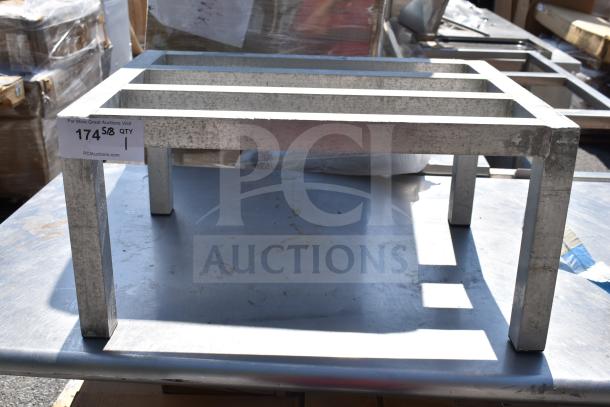 Commercial Dunnage Rack made of metal with four legs and a slatted top. Visible wear, auction label attached.