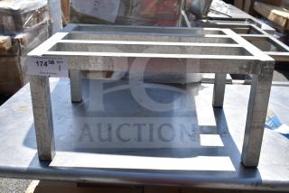 Commercial Dunnage Rack made of metal with four legs and a slatted top. Visible wear, auction label attached.