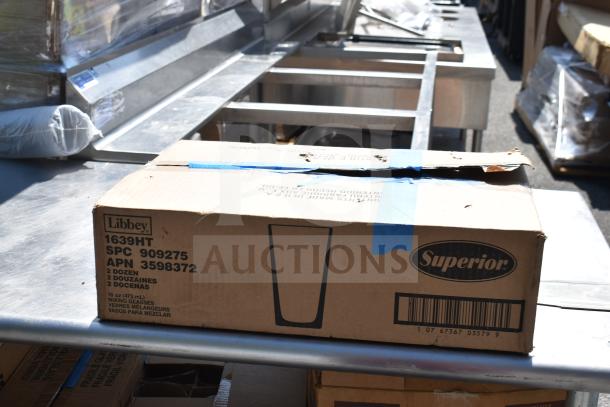 Commercial table with contents, including Libbey glasses and baking pans in cardboard box, marked "Superior".