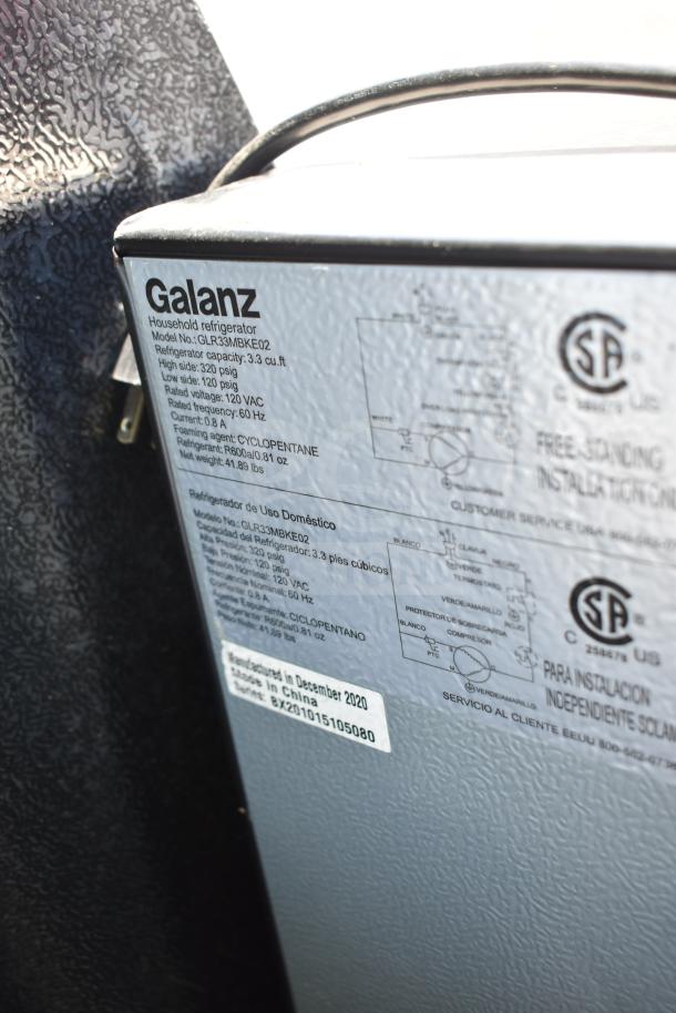 Close-up of a Galanz GLR33MBKE02 cooler label showing specs: 3.3 cu.ft, 120V, 60Hz, and December 2020 manufacture date.