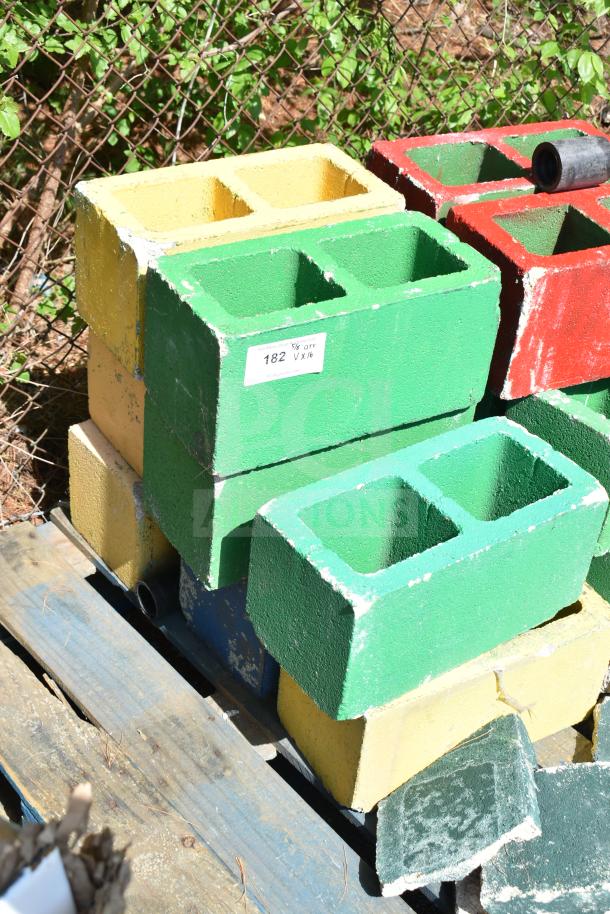 Painted cinderblocks in yellow, green, and red, sold in lots of 16. Condition varies; some chipping visible. Label shows item 182, qty 1x16.
