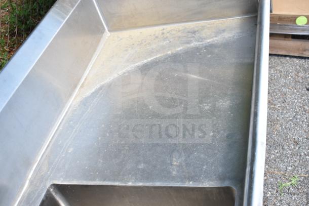 Commercial 3 bay sink with dual drain boards, stainless steel, showing surface wear and minor scratches. Ideal for kitchen use.