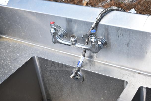 Commercial 3-bay sink with dual drain boards, stainless steel, used condition, dual faucet handles, fixed plumbing.