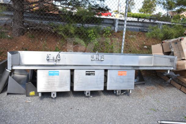 Commercial 3 bay sink with dual drain boards, stainless steel construction. Features labeled wash, rinse, sanitize bays. Good condition.