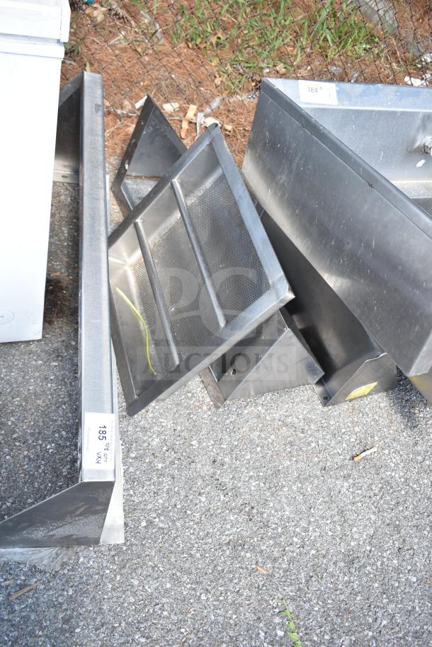 Four metal items including three shelves and a drop-in sink strainer, in used condition, with visible auction labels.